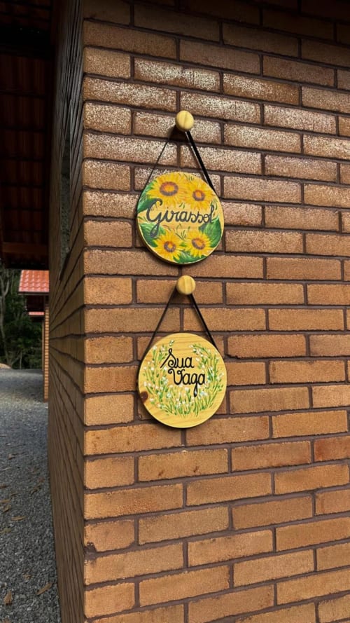 Placas decorativas amarelas da villa Chalé Girassol em Vivendas Canaã, Espera Feliz, com desenhos de girassóis e ervas
