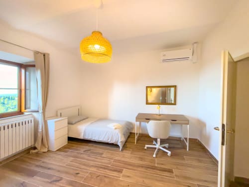 Bright Serena bedroom at Tuscan Sun Stays with single bed, desk, yellow pendant light, wooden floors, mountain views