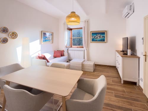 Serena apartment at Tuscan Sun Stays: bright modern living room with dining table, sitting area, mountain views, and full