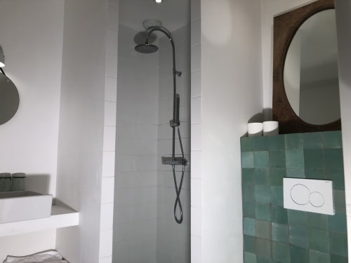 Salle de bain moderne au B&B Denis & Virginie à Versailles avec pomme de douche pluie, lavabo blanc, carrelage vert et détails ronds