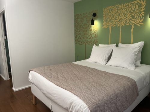 Chambre moderne au gîte Denis & Virginie à Versailles avec mur d'accent vert, arbustes décoratifs, literie blanche