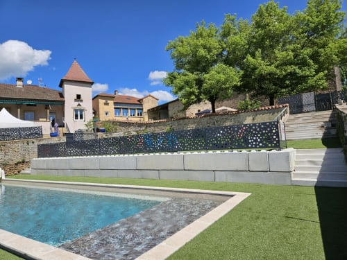 Vue du jardin des Gîtes Les Muriers avec piscine, terrasse et bâtisses en pierre traditionnelle à Bourgvilain