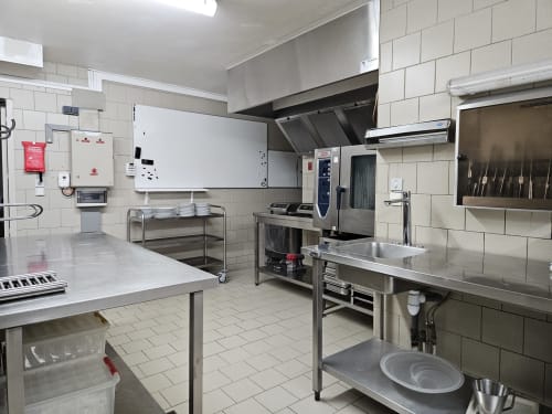 Cuisine professionnelle du gîte Les Muriers avec équipements inox, tables de préparation et matériel de cuisson