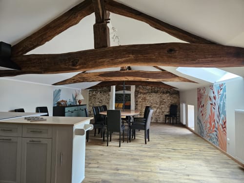 Cuisine ouverte et salle à manger du Gîte Ornella aux Gites Les Muriers, Bourgvilain, avec poutres apparentes et cheminée en pierre