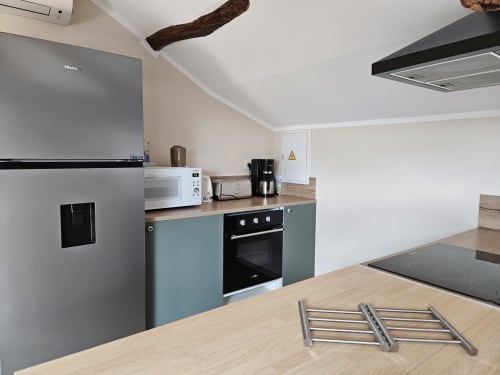 Cuisine moderne du Gîte Ornella aux Gîtes Les Muriers avec électroménagers inox et plan de travail bois