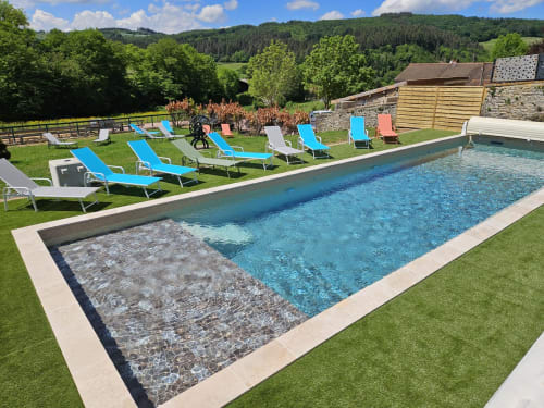 Piscine avec transats aux Gîtes Les Muriers à Bourgvilain, France, vue sur les jardins et la campagne