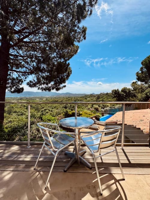 Terrasse de la Villa Anchorage avec vue mer, table à manger, chaises et piscine privée surplombant le paysage corse aux Villas