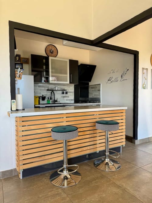Cuisine moderne avec bar en bois et tabourets noirs à la Villa Anchorage des Villas d'A Storia, Porto-Vecchio