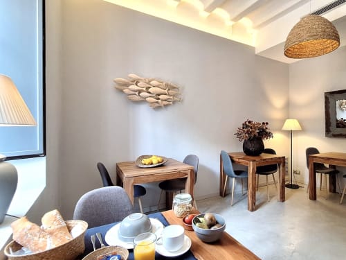 Salle à manger de l'Hôtel Casa Calella avec tables en bois, chaises modernes, décoration côtière et lumière naturelle à Calella de Palafrugell