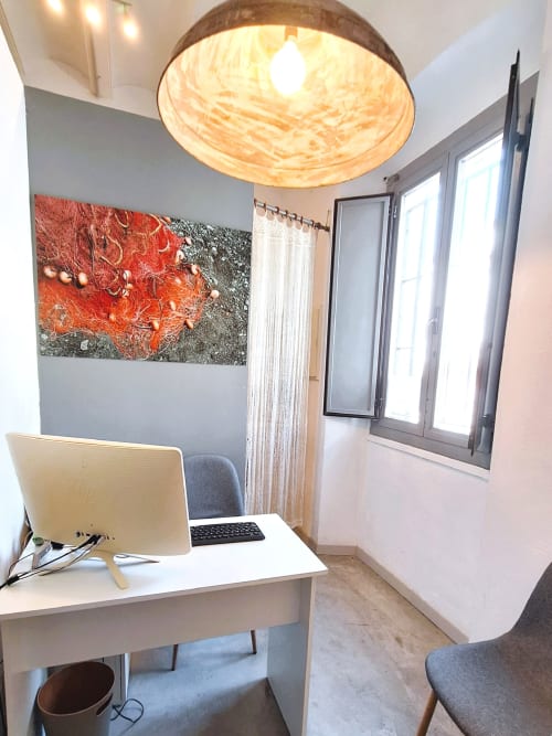 Espace de travail moderne à l'Hôtel Casa Calella avec bureau, ordinateur et art mural abstrait à Calella de Palafrugell