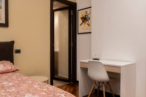 Camera Vittoria di ROOMITO APARTMENTS a Napoli: moderna camera da letto con scrivania, pavimenti in legno e arredi contemporanei