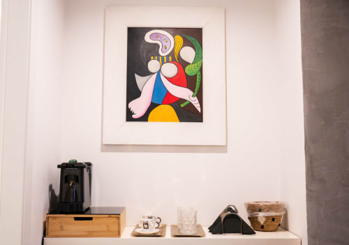 Colorful abstract artwork above shelf with coffee maker and decor in ROOMITO APARTMENTS Naples