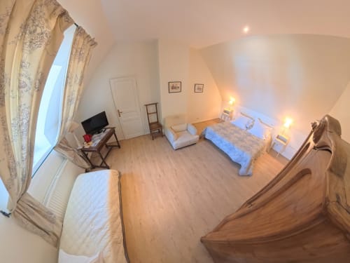 Spacious bedroom at Ferme De La Sensee with two beds, TV, wooden furniture and natural light from large window