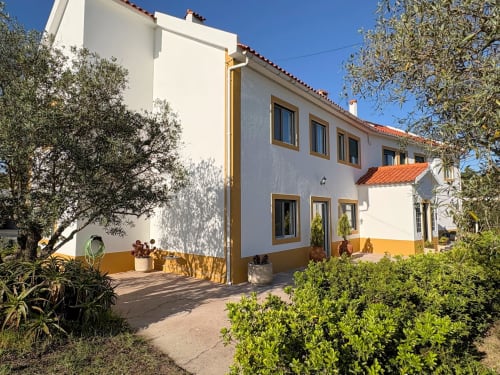 Fachada externa da Quinta Vale da Paz B&B em Azambuja, Portugal com fachada branca e amarela, telhado em barro, oliveiras e