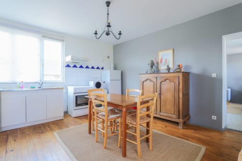 Cuisine-salle à manger lumineuse du gîte Maison Nolette en Baie de Somme avec table en bois, mobilier vintage et vue sur le jardin
