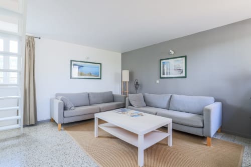 Salon moderne à la Maison Nolette en Baie de Somme avec canapés gris et table basse blanche