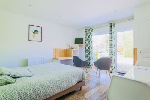 Studio lumineux à la Maison Nolette en Baie de Somme avec lit, bureau, TV et vue sur le jardin par les portes-fenêtres