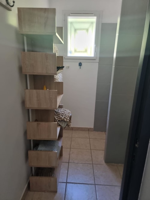 Corridoio bagni con scaffalature in legno e pavimentazione in piastrelle presso la villa Conciergerie De Porticcio a Porticcio