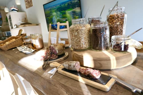 Colazione all'Hotel Les Mouettes con salumi, frutta secca e cereali su tavolo di legno a Belgodère