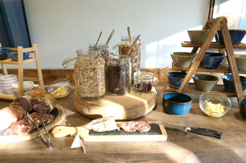 Colazione all'Hotel Les Mouettes con cereali, marmellate, salumi, formaggi e ciotole in ceramica blu in sala luminosa