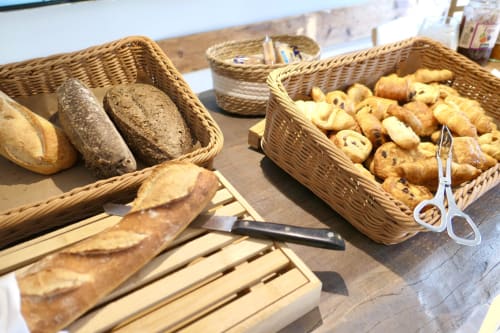 Vetrina della panetteria dell'Hotel Les Mouettes con pane fresco, croissant e pasticcini in cesti di vimini