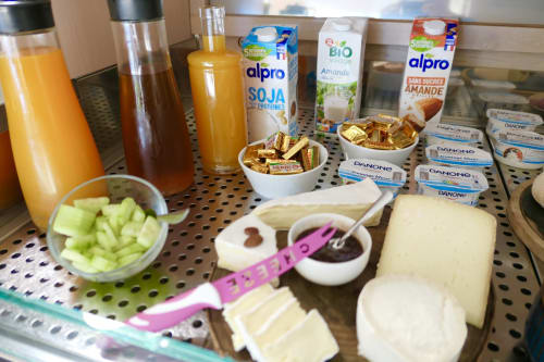 Mensola colazione dell'Hotel Les Mouettes con succhi di frutta, latte di soia Alpro, yogurt, formaggio e frutta fresca a Belgodère