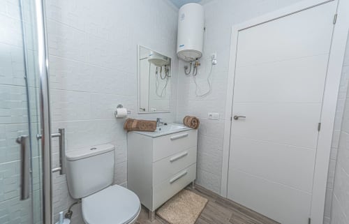 Baño moderno y luminoso en apartamento Casa Sol, Tarajalejo, Fuerteventura con lavabo, inodoro, ducha y calentador de agua eléctrico
