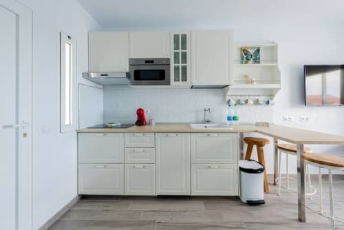 Cocina moderna del apartamento Casa Sol en Tarajalejo, Fuerteventura, con muebles color crema, electrodomésticos de acero inoxidable y comedor