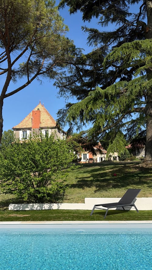 La piscine et la tour du Domaine les Olivoux à Pomport, France avec chaise longue et jardins entretenus