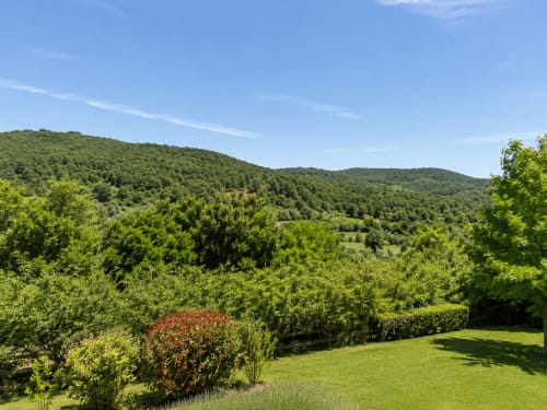 Vista de exuberante jardín verde y paisaje montañoso desde la Vila Lourido Holibai en Baiona, España