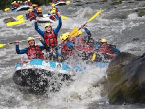 Groupe de rafting en eaux vives avec pagaies jaunes sur les rapides tumultueux près de Belle Plagne