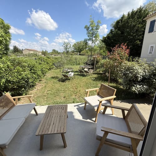 Terrasse vue jardin de la villa Maisons Le Clos Du Moulin avec coin détente et verdure luxuriante à Entraigues sur la Sorgue
