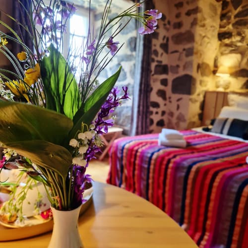 Arrangement floral aux fleurs violettes et feuillage vert dans une chambre du Mas De Rigoulac, Aubrac