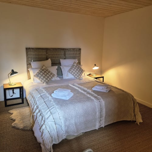 Chambre Nuage au Mas De Rigoulac, chambre de luxe avec tête de lit tissée, draps blancs et éclairage chaleureux