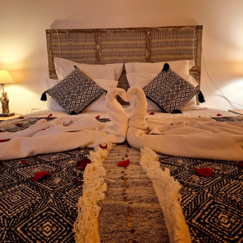 Chambre romantique au Mas De Rigoulac avec serviettes cygne, coussins décoratifs et pétales de rose
