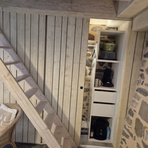 Escalier en bois et rangements intégrés avec étagères au Gîte Le Four du Mas De Rigoulac, Argences-en-Aubrac