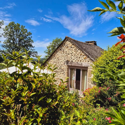 Gîte en pierre Le Four au Mas De Rigoulac entouré d'un jardin fleuri à Argences-en-Aubrac