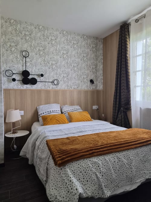 Chambre de la villa L'effet Mer Parenthese à Pénéstin avec papier peint à motifs, mur en bois et coussins dorés
