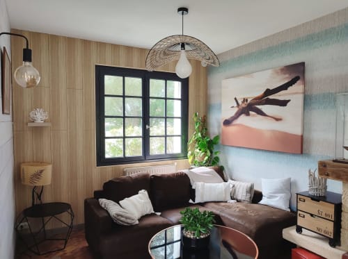 Salon moderne de la villa L'effet Mer Parenthese à Pénéstin avec canapé noir, baie vitrée sur jardin et œuvres d'art contemporain