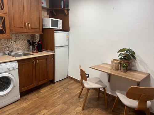Cocina rústica moderna en Iznatoraf con muebles de madera, comedor y vistas a las montañas en Casa de la Aguadora