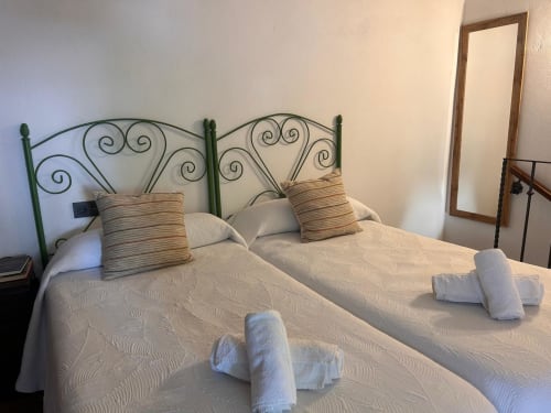 Camas gemelas con cabecero de hierro forjado en la casa rural Casa de la Aguadora en Iznatoraf, España