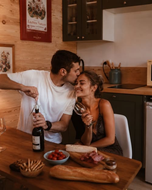 Couple savourant du vin et une planche charcuterie dans la cuisine moderne des Chalets de Mosnay, Mosnay