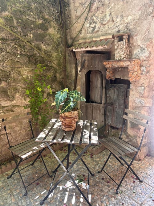 Patio rústico de Casa de la Aguadora en Iznatoraf con área de descanso, plantas en macetas y muros de piedra desgastados