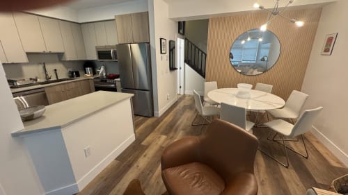 Modern open-concept kitchen and dining area in Northstar 60 apartment at Whistler with stainless steel appliances, white
