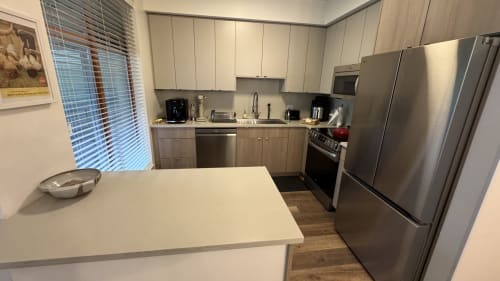 Modern kitchen in Northstar 60 Whistler apartment with stainless steel appliances, white cabinetry, and dining counter