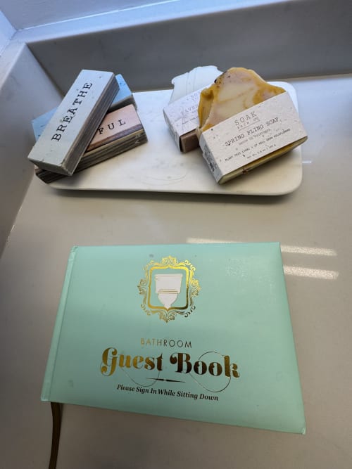 Bathroom amenities at Whistler B&B including artisan soaps and decorative guest book with mint-green cover