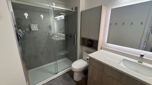 Modern bathroom at Northstar 60 in Whistler with shower, toilet, vanity sink, and mirror
