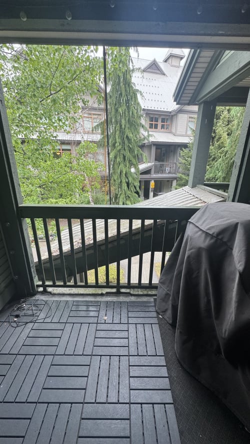 Mountain view balcony at Northstar 60 Whistler apartment with deck and railing overlooking tree-lined neighborhood