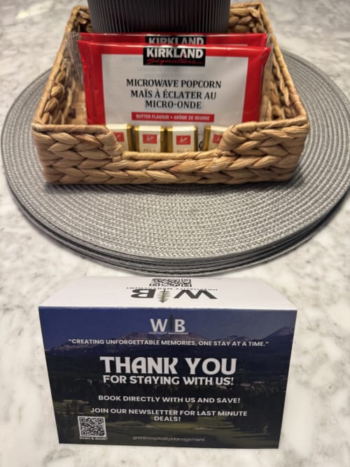 Kirkland microwave popcorn gift basket with milk chocolates and WB Hospitality thank you card at Whistler accommodation.