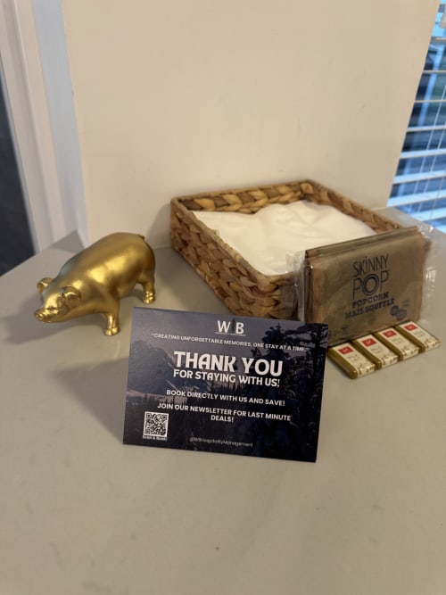 WB Hospitality welcome basket with gold pig figurine, popcorn, matches, and thank you card in Whistler apartment